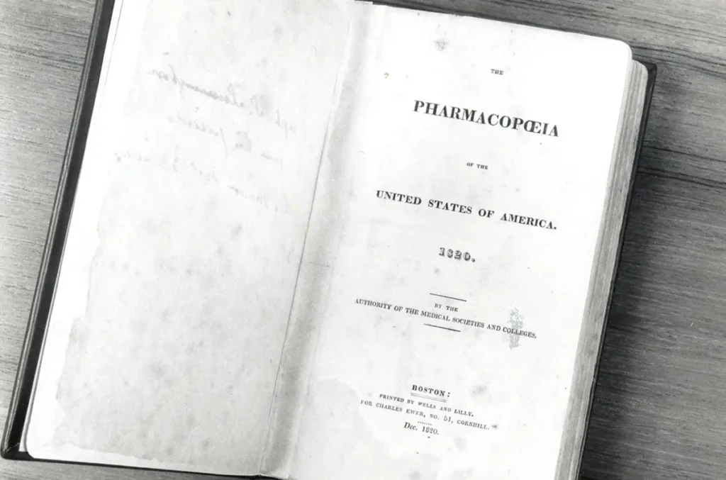 An open book displaying the title page of the "Pharmacopeia of the United States of America, 1820."