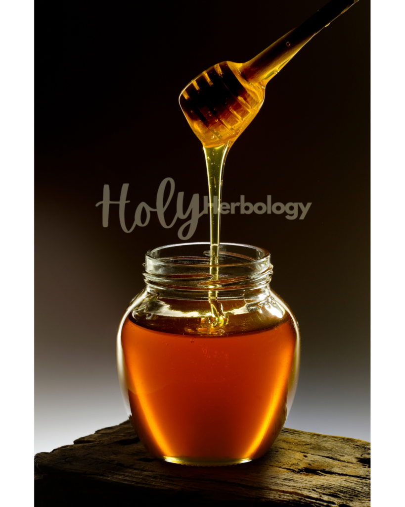 A wooden honey dipper drips golden honey into a glass jar filled with honey. The jar is placed on a rustic wooden surface. The background is dark with a gradient of light, highlighting the honey's rich color and texture. The text "Holy Herbology" is partially visible across the image. Honey contain secret immunity boosting properites.